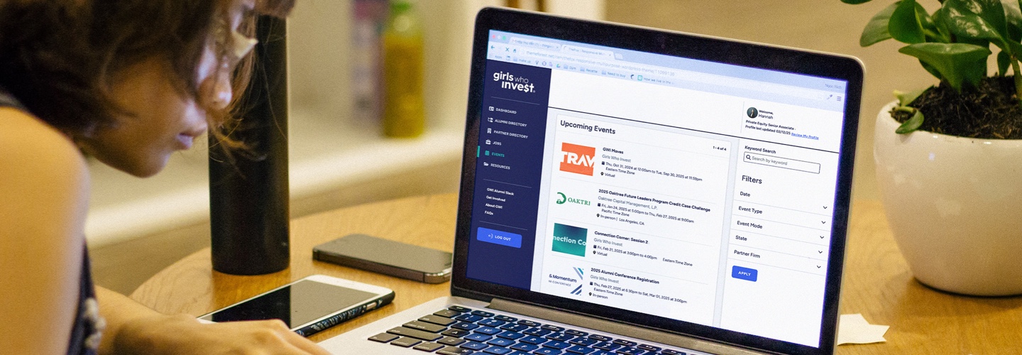 a woman looking at the alumni porta on a laptop